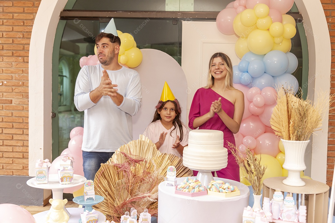 Pai e mãe fazendo aniversário para sua filha