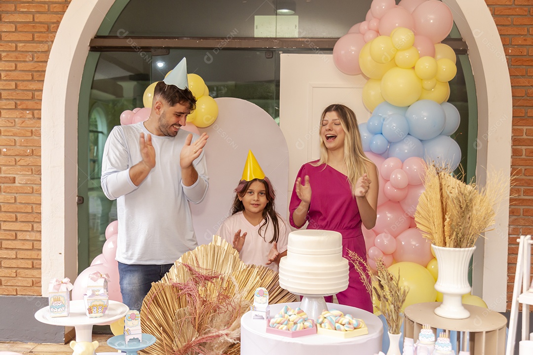 Pai e mãe fazendo aniversário para sua filha