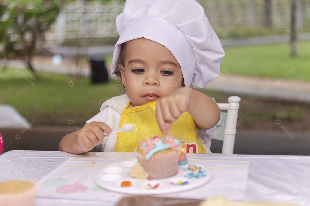 Criança fofa usando roupas de chefe de cozinha