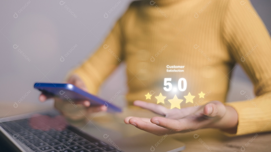 Mulher segurando um telefone celular e um laptop com classificação de 5 estrelas no telefone