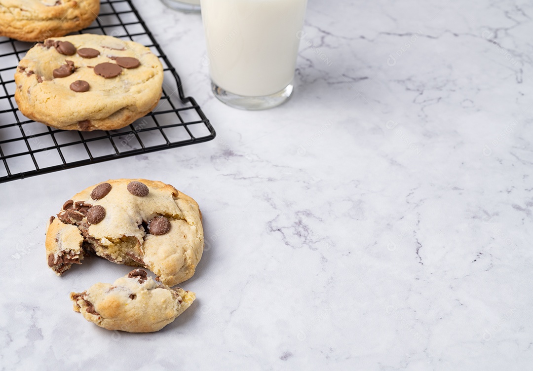 Biscoitos de chocolate encima de grandinha copo de leite sobre fundo de pedra