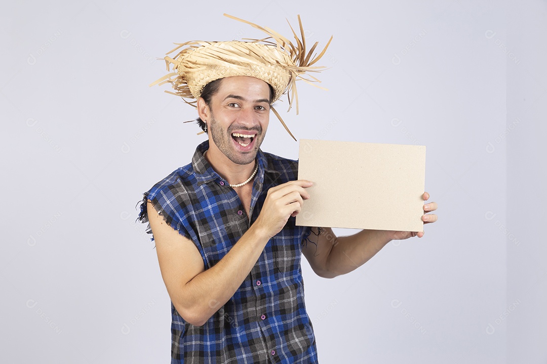 Homem jovem usando roupas típicas de festa junina segurando placa sobre fundo isolado