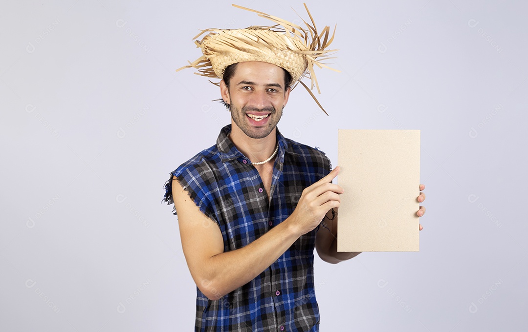 Homem jovem usando roupas típicas de festa junina segurando placa sobre fundo isolado