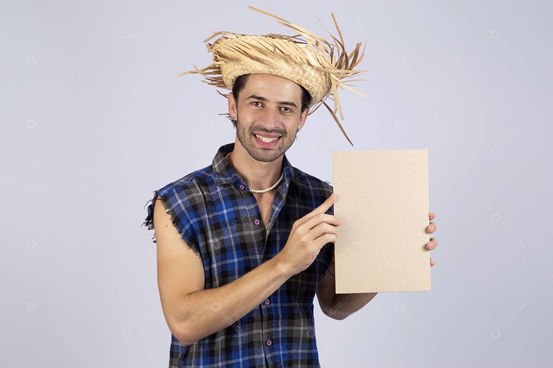 Homem jovem usando roupas típicas de festa junina segurando placa sobre fundo isolado