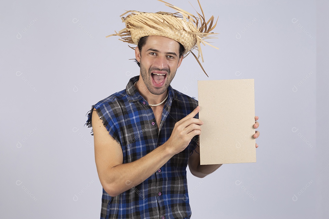 Homem jovem usando roupas típicas de festa junina segurando placa sobre fundo isolado