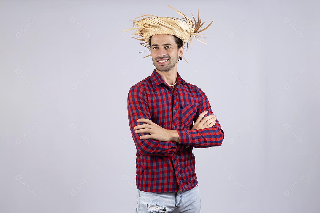 Homem jovem usando roupas típicas de festa junina braços cruzados sobre fundo isolado