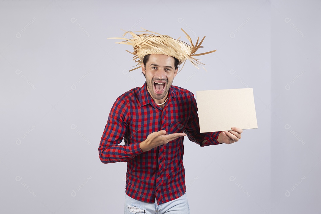 Homem jovem usando roupas típicas de festa junina segurando placa sobre fundo isolado