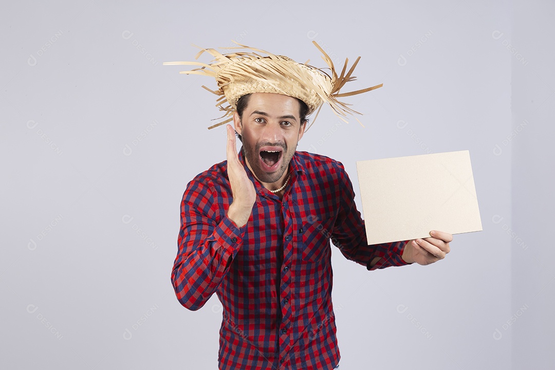 Homem jovem usando roupas típicas de festa junina segurando placa sobre fundo isolado