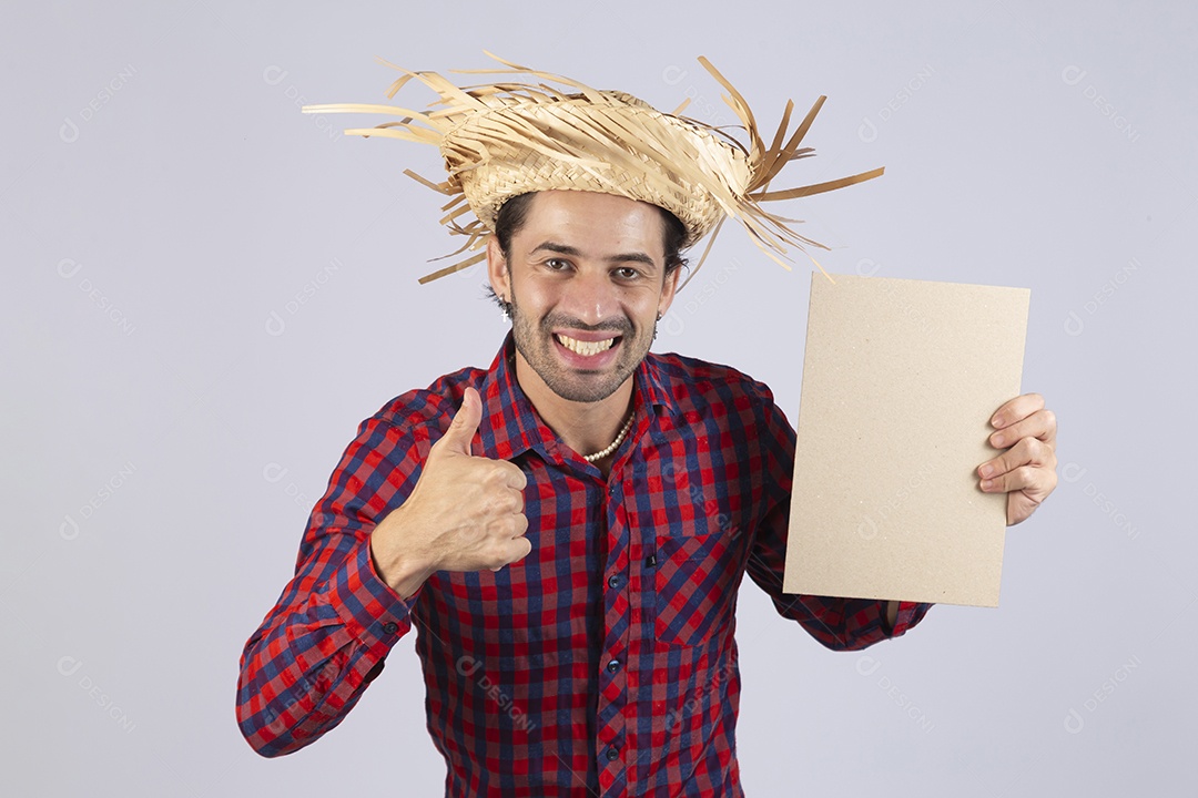 Homem jovem usando roupas típicas de festa junina segurando placa sobre fundo isolado
