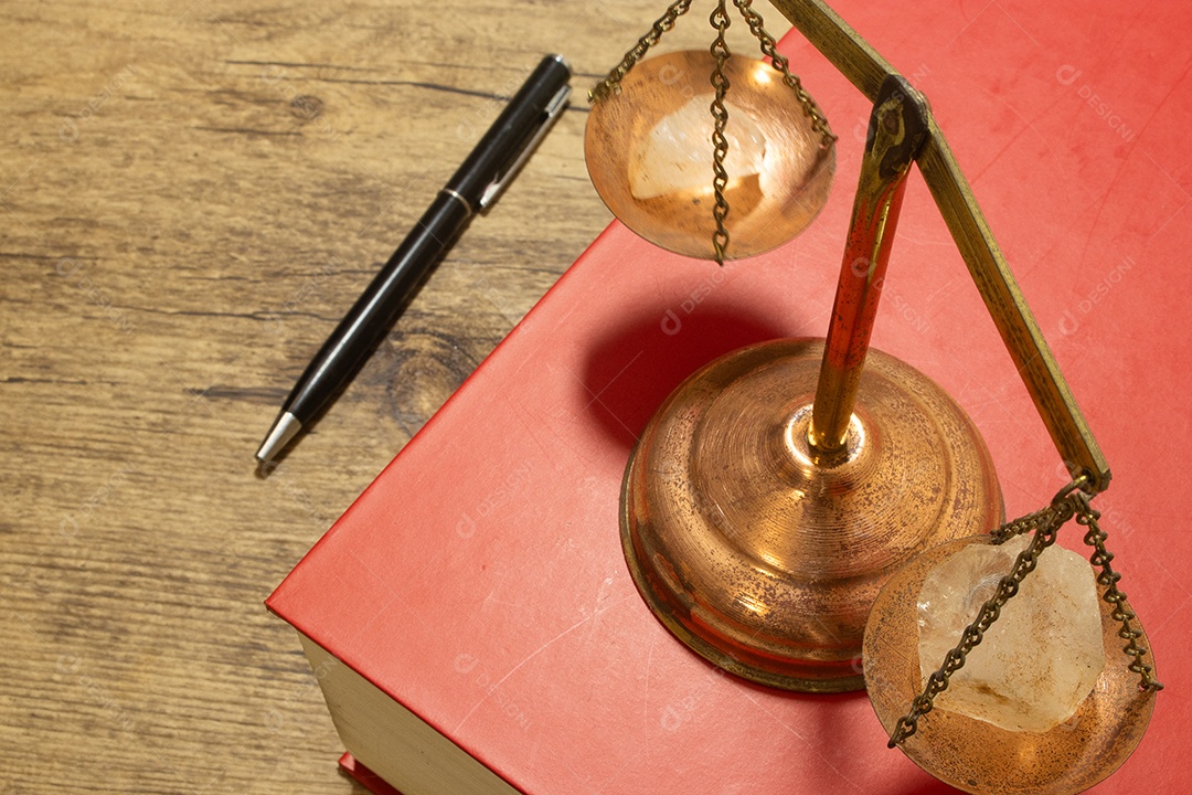 Balança da justiça perto de um livro