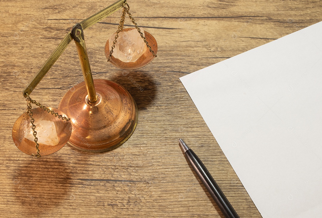 Balança da justiça perto de uma folha de papel em branco