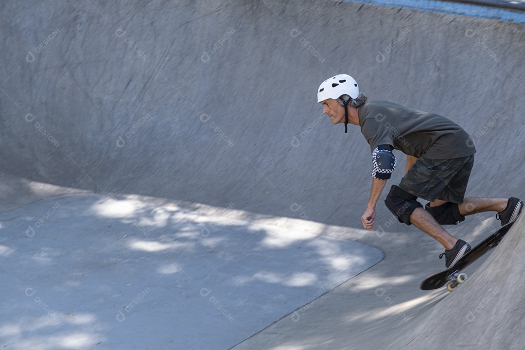 Homem descendo de skate uma rampa