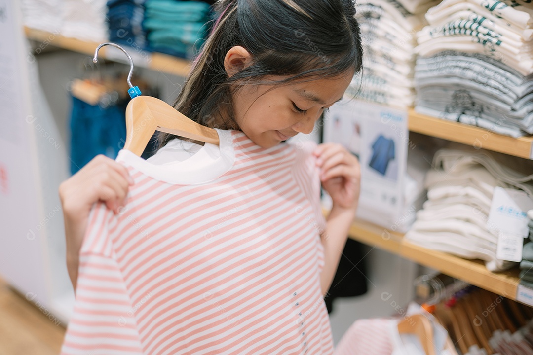 Menina provando blusa rosa