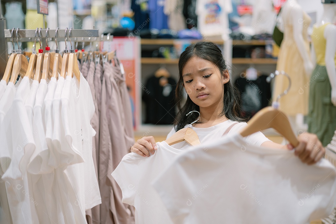 Garota olhando para peça de roupa em lojas