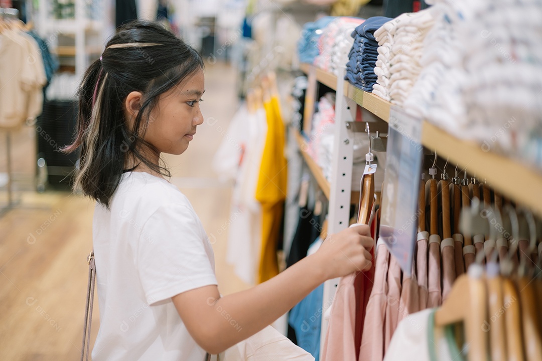Uma garota escolhendo roupas na loja