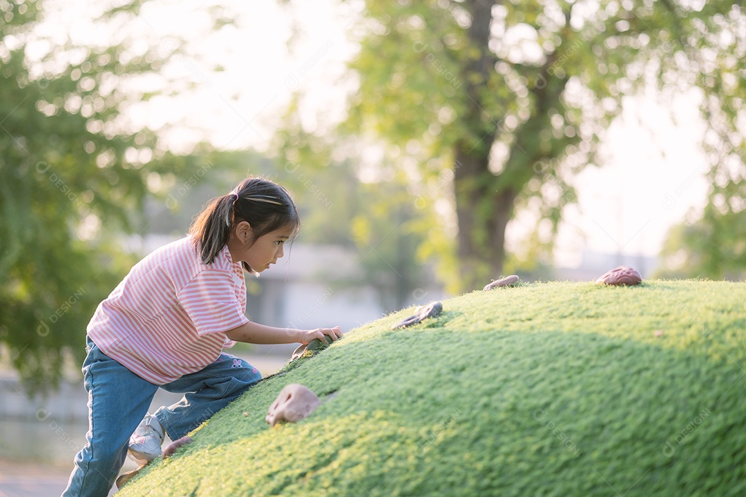 Garotinha está subindo uma colina gramada