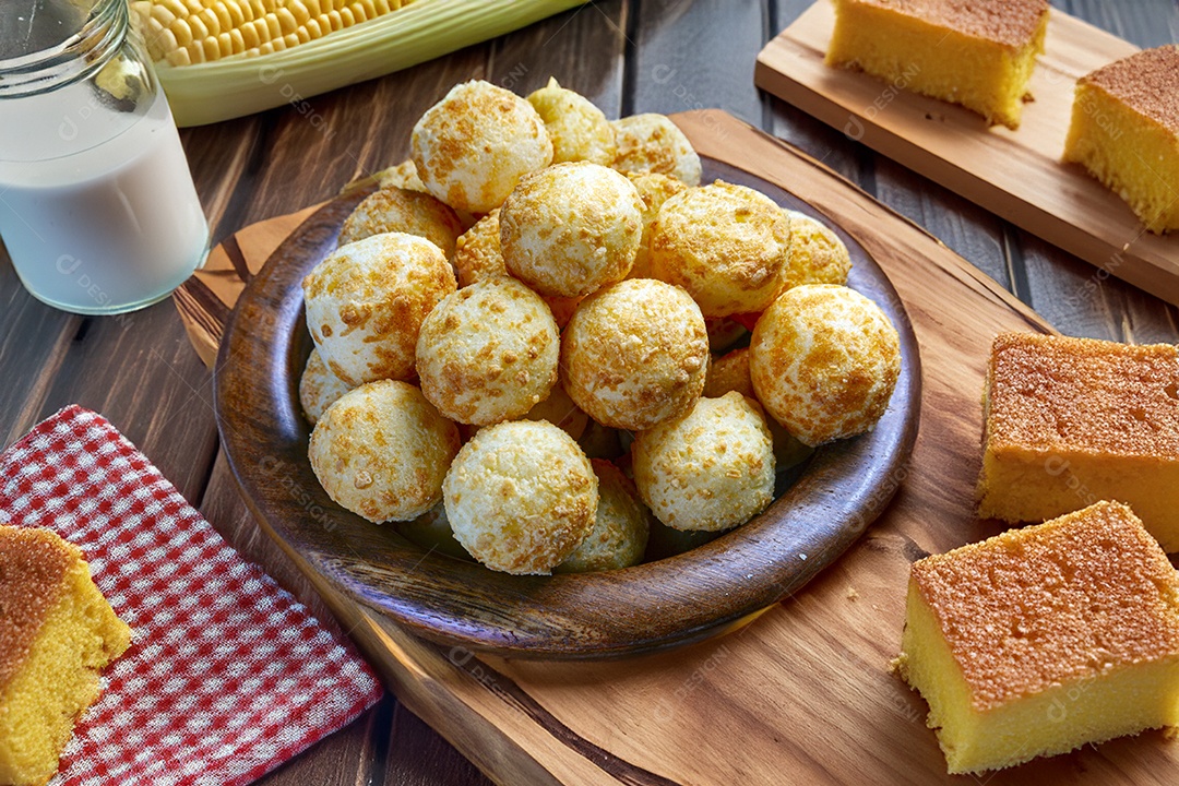 Pão de queijo sobre uma mesa com bolos em cima de uma mesa