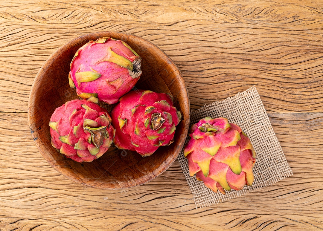 Tigela com pitayas sobre uma mesa de madeira