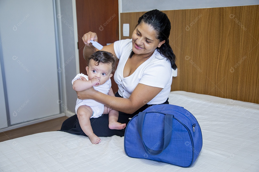 Mãe jovem cuidadando de seu filho sobre quarto