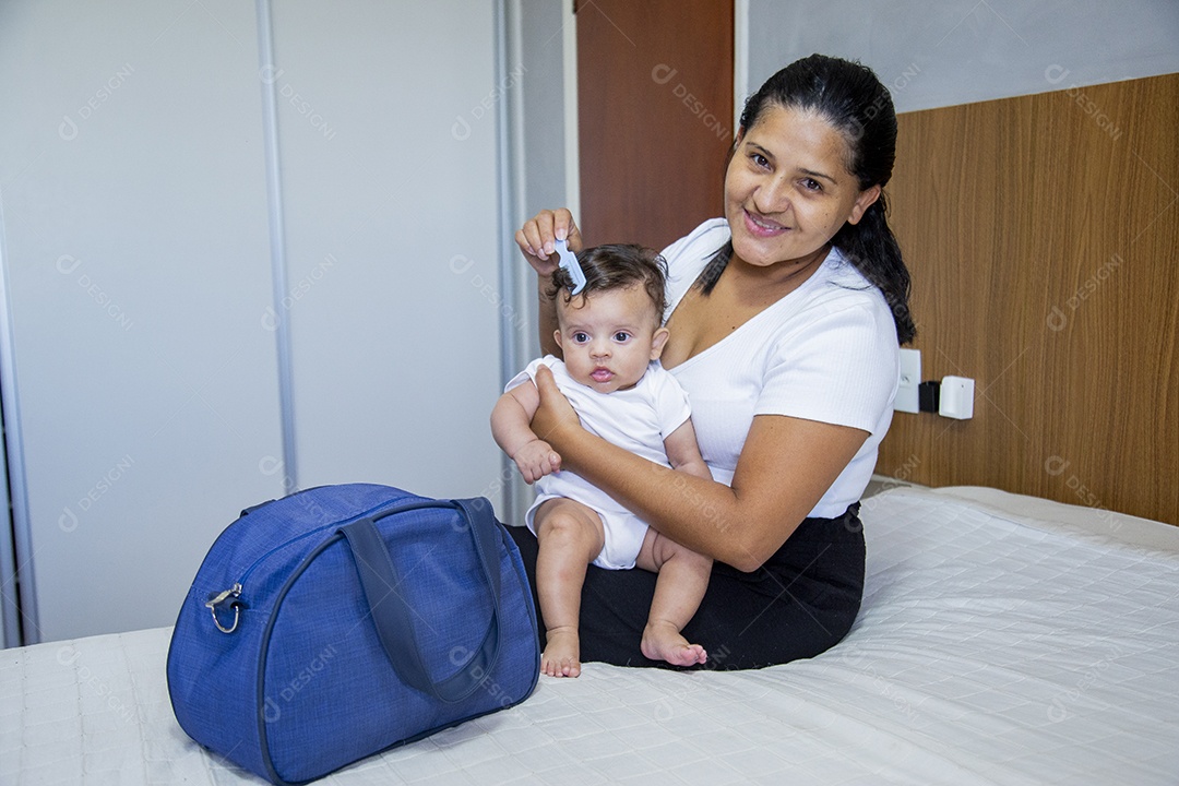 Mãe jovem cuidadando de seu filho sobre quarto