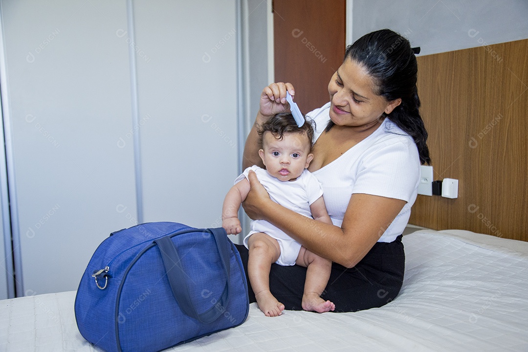 Mãe jovem cuidadando de seu filho sobre quarto