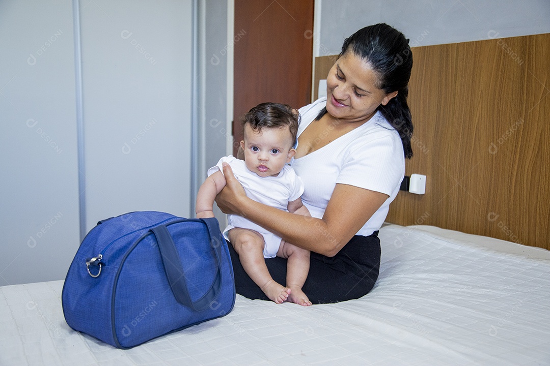 Mãe jovem cuidadando de seu filho sobre quarto