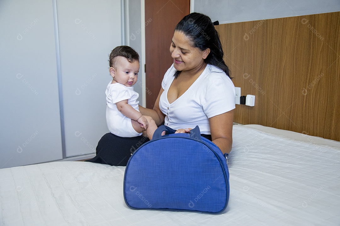 Mãe jovem cuidadando de seu filho sobre quarto