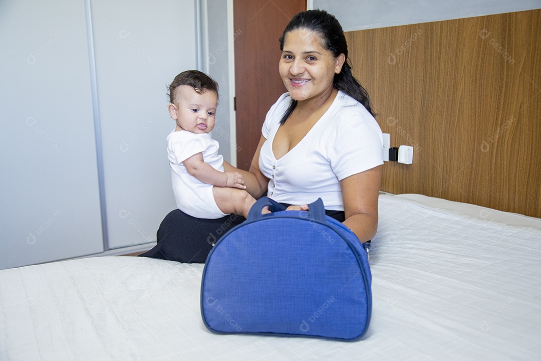 Mãe jovem cuidadando de seu filho sobre quarto