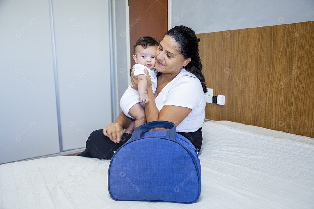 Mãe jovem cuidadando de seu filho sobre quarto