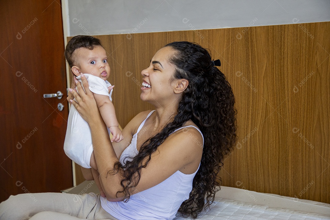 Mãe jovem cuidadando de seu filho sobre quarto