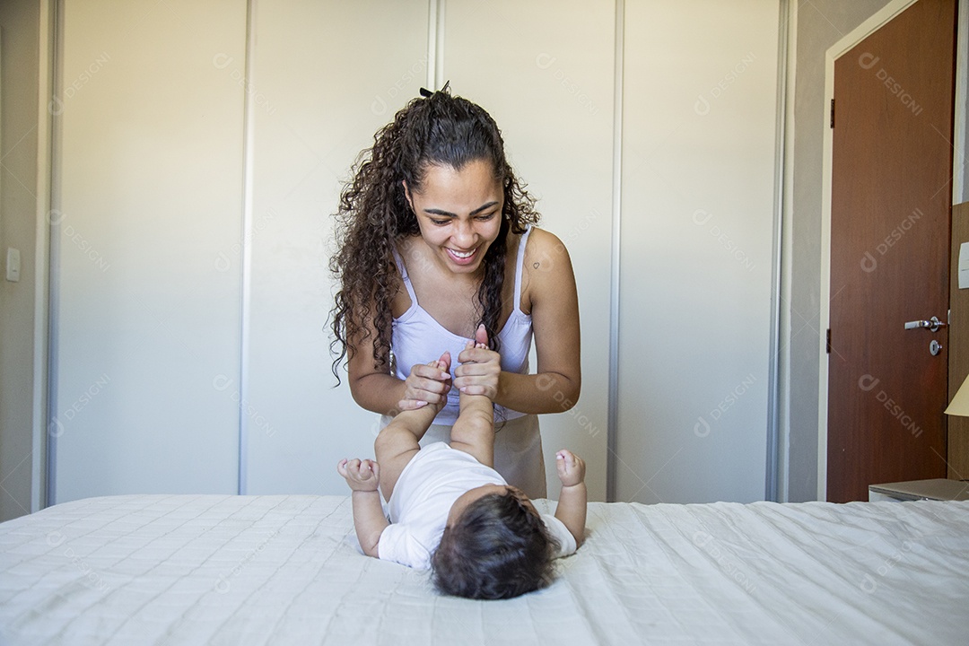 Mãe jovem cuidadando de seu filho sobre quarto