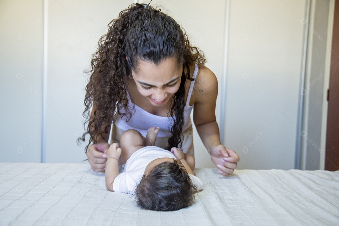 Mãe jovem cuidadando de seu filho sobre quarto