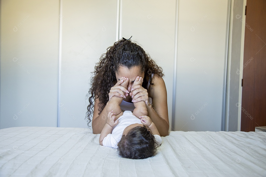 Mãe jovem cuidadando de seu filho sobre quarto