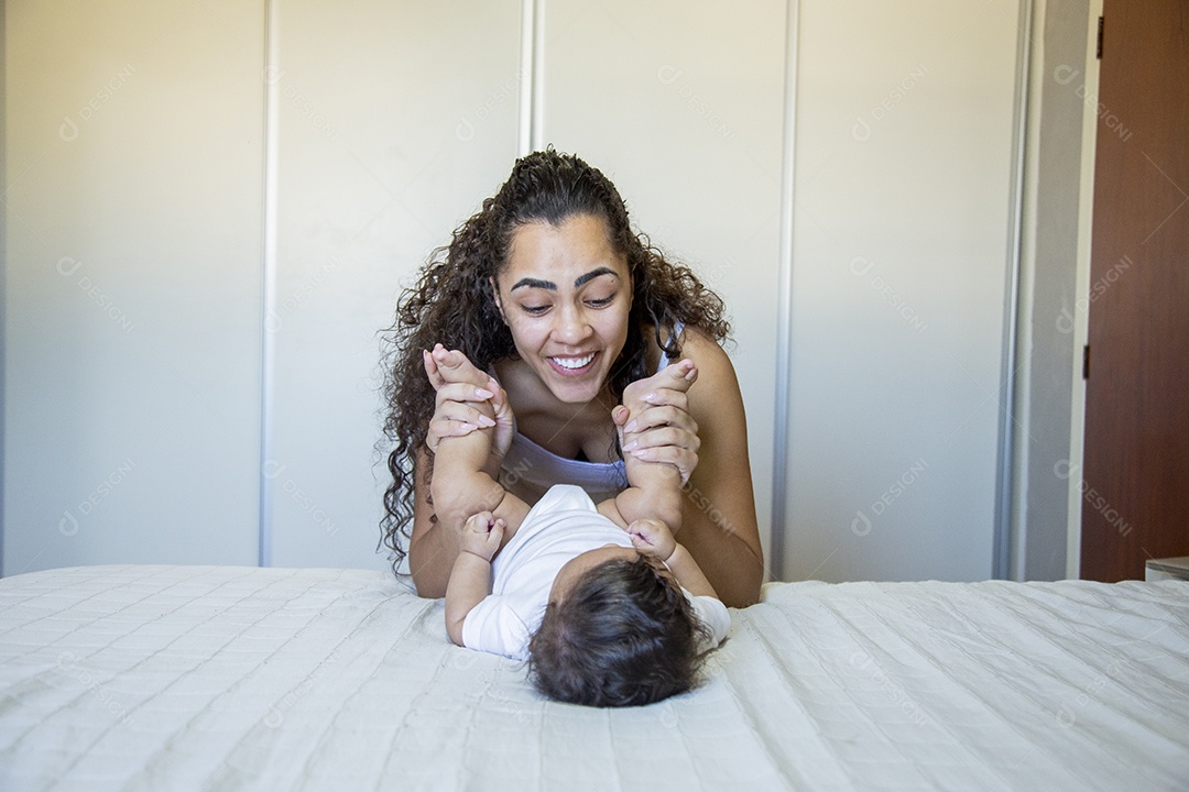 Mãe jovem cuidadando de seu filho sobre quarto
