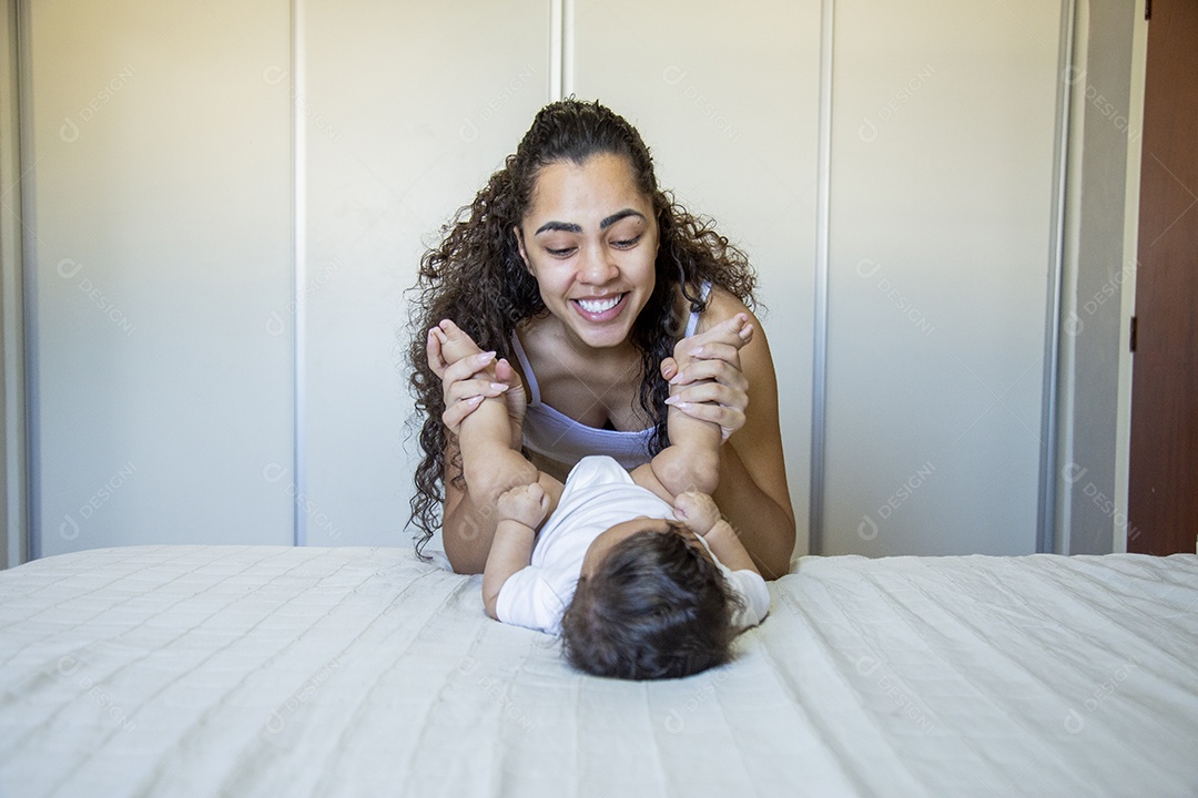 Mãe jovem cuidadando de seu filho sobre quarto