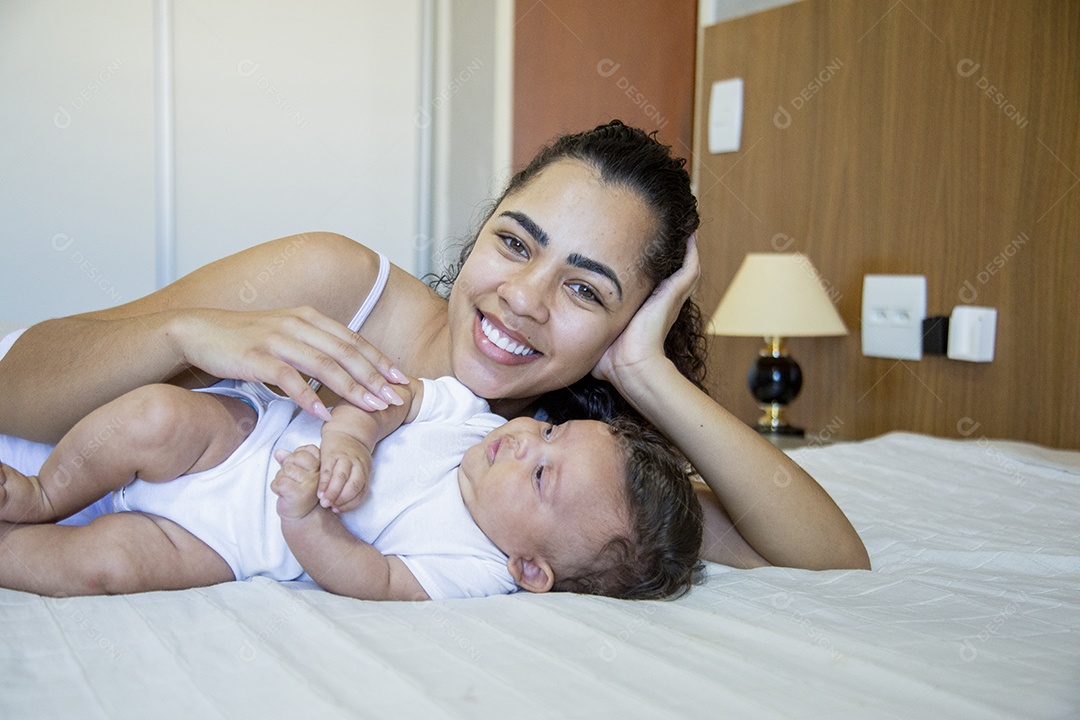 Mãe jovem cuidadando de seu filho sobre quarto
