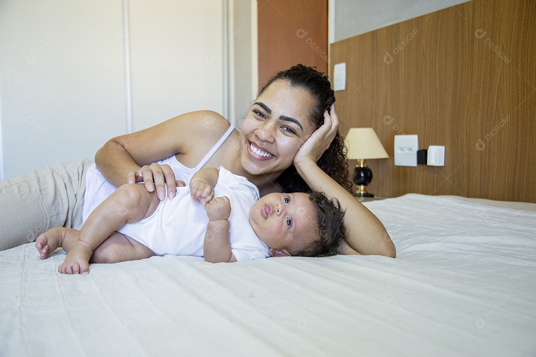 Mãe jovem cuidadando de seu filho sobre quarto