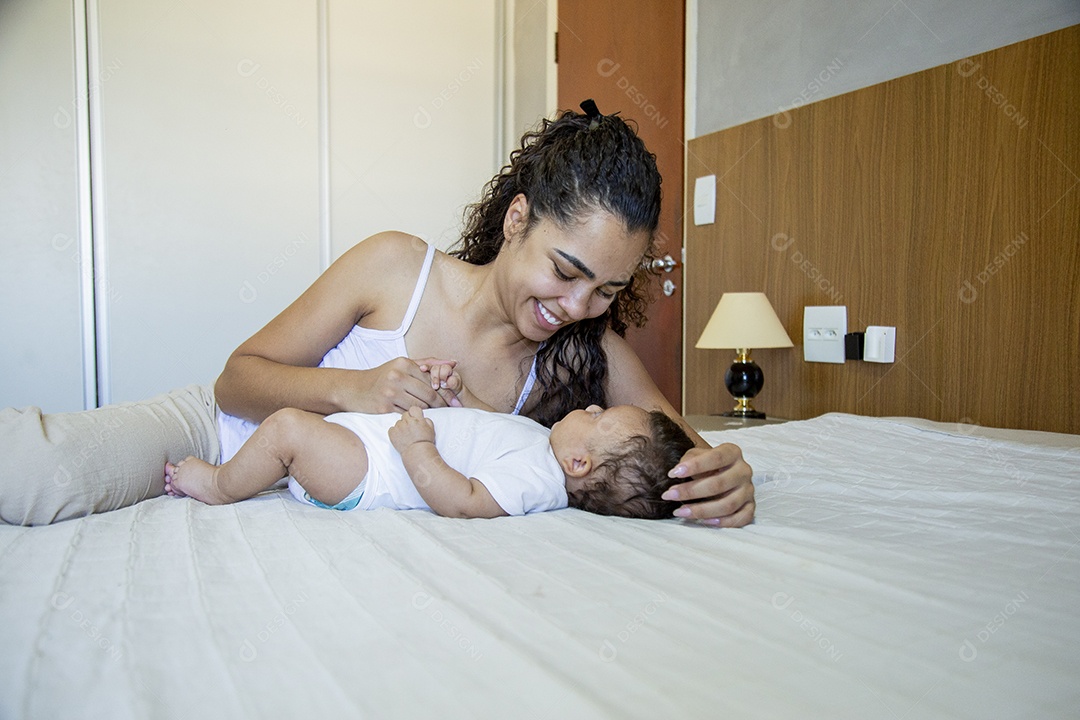 Mãe jovem cuidadando de seu filho sobre quarto