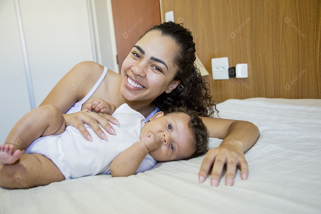 Mãe jovem cuidadando de seu filho sobre quarto