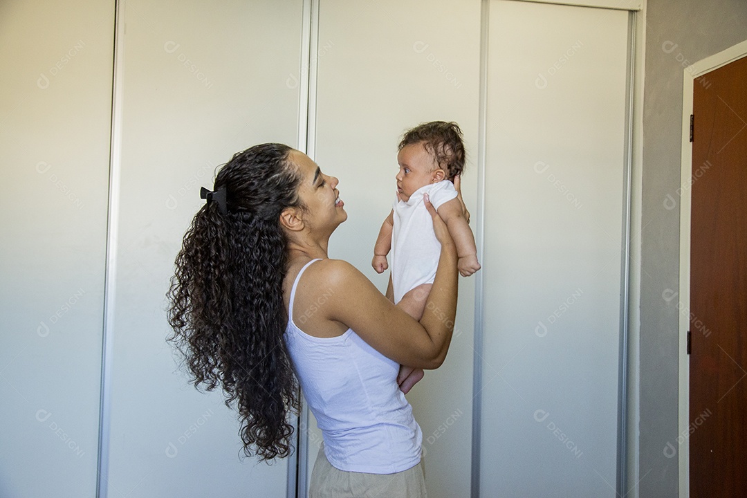 Mãe jovem cuidadando de seu filho sobre quarto