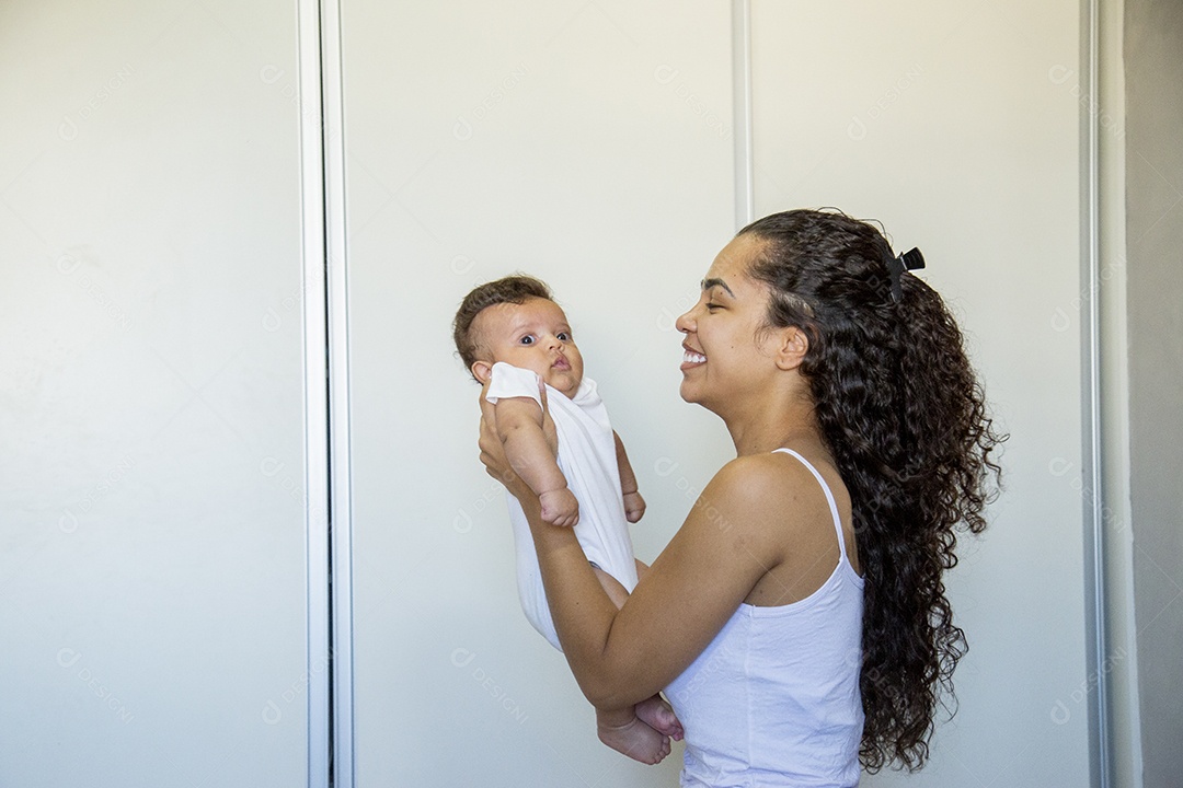 Mãe jovem cuidadando de seu filho sobre quarto