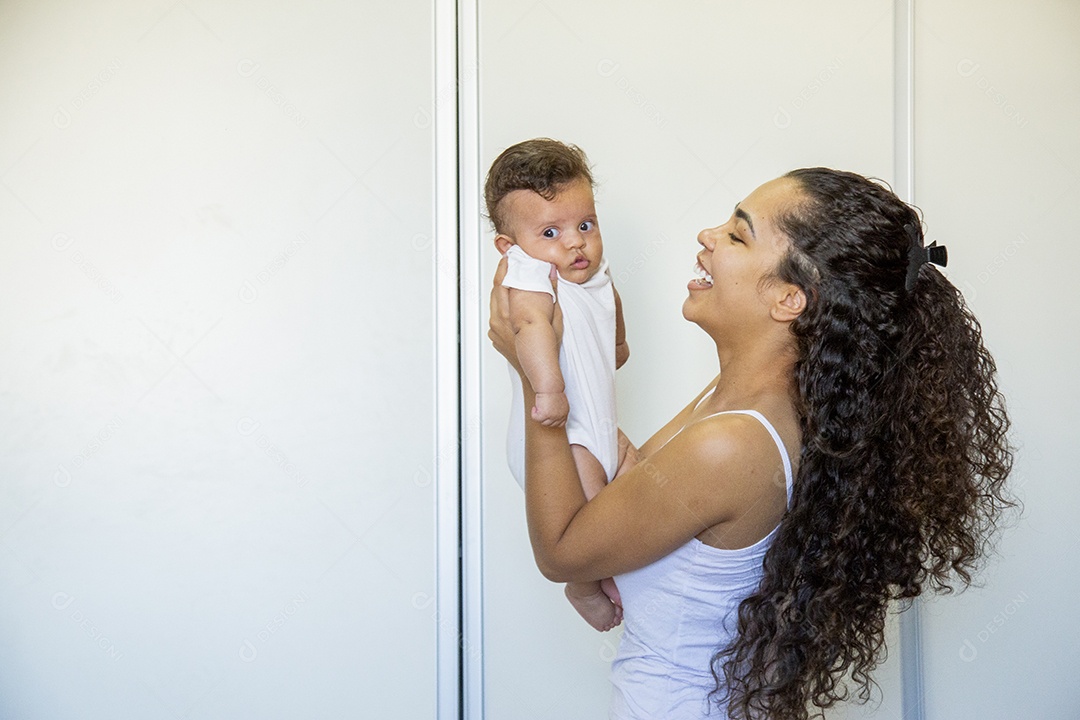 Mãe jovem cuidadando de seu filho sobre quarto