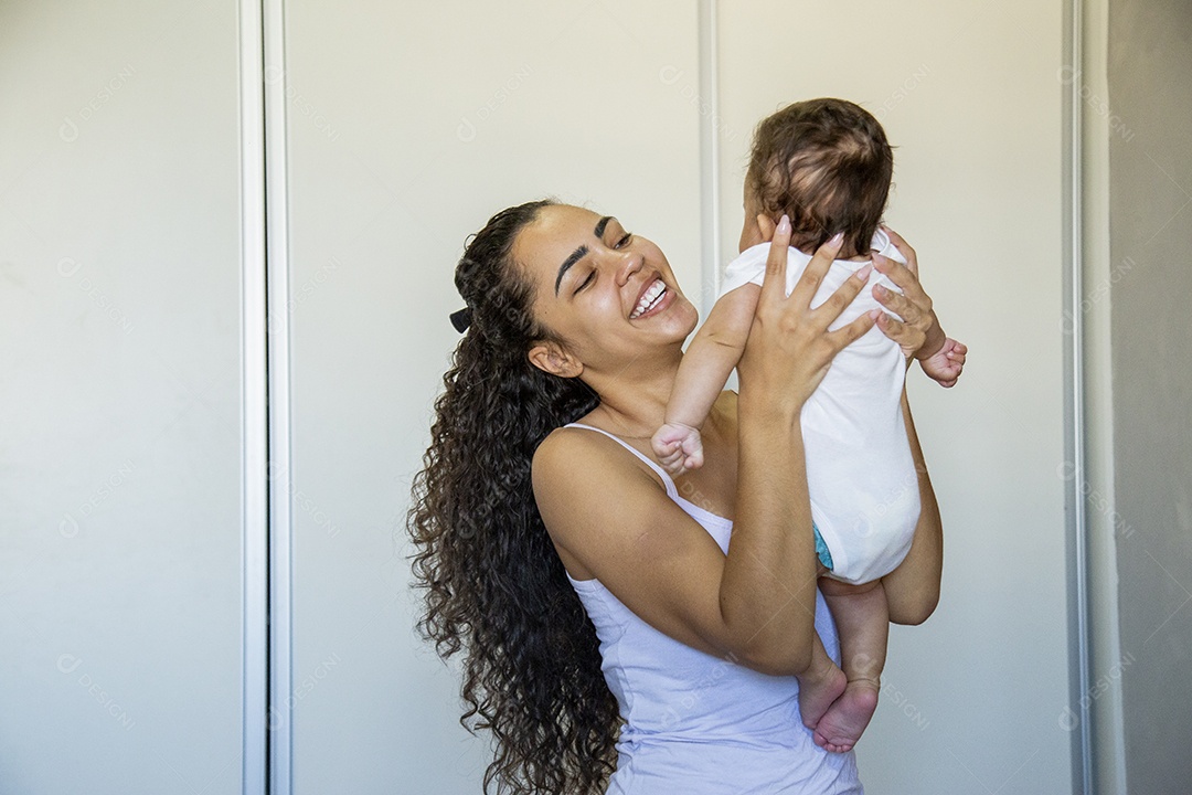 Mãe jovem cuidadando de seu filho sobre quarto