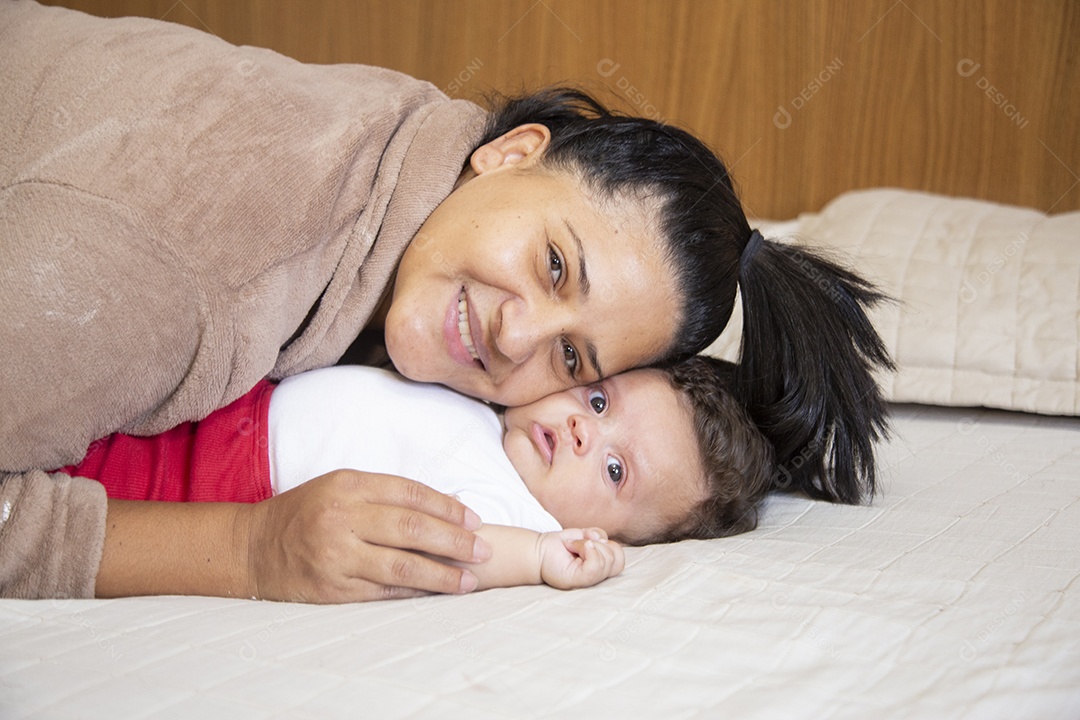 Mãe jovem cuidadando de seu filho sobre quarto