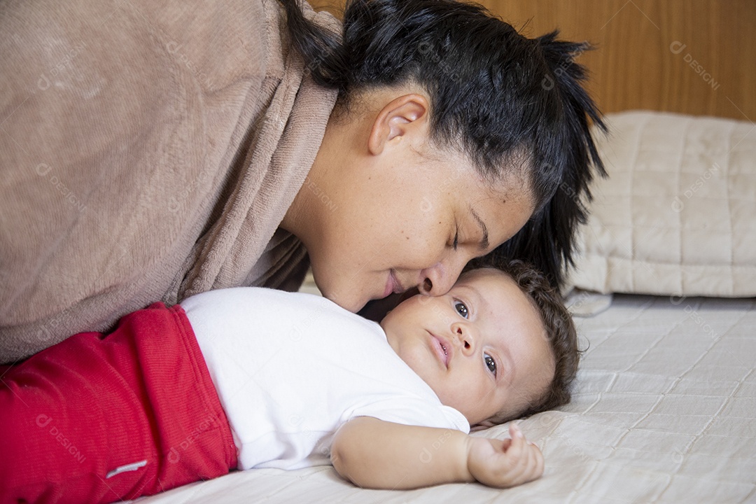 Mãe jovem cuidadando de seu filho sobre quarto