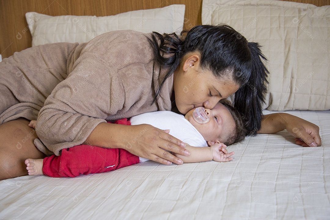 Mãe jovem cuidadando de seu filho sobre quarto