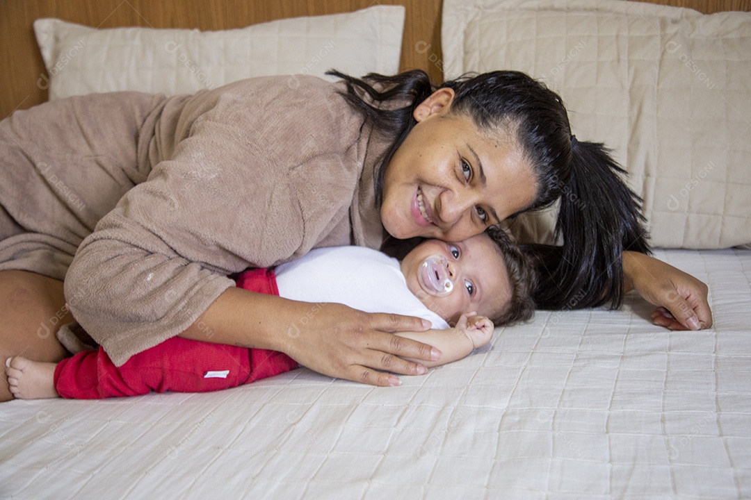 Mãe jovem cuidadando de seu filho sobre quarto