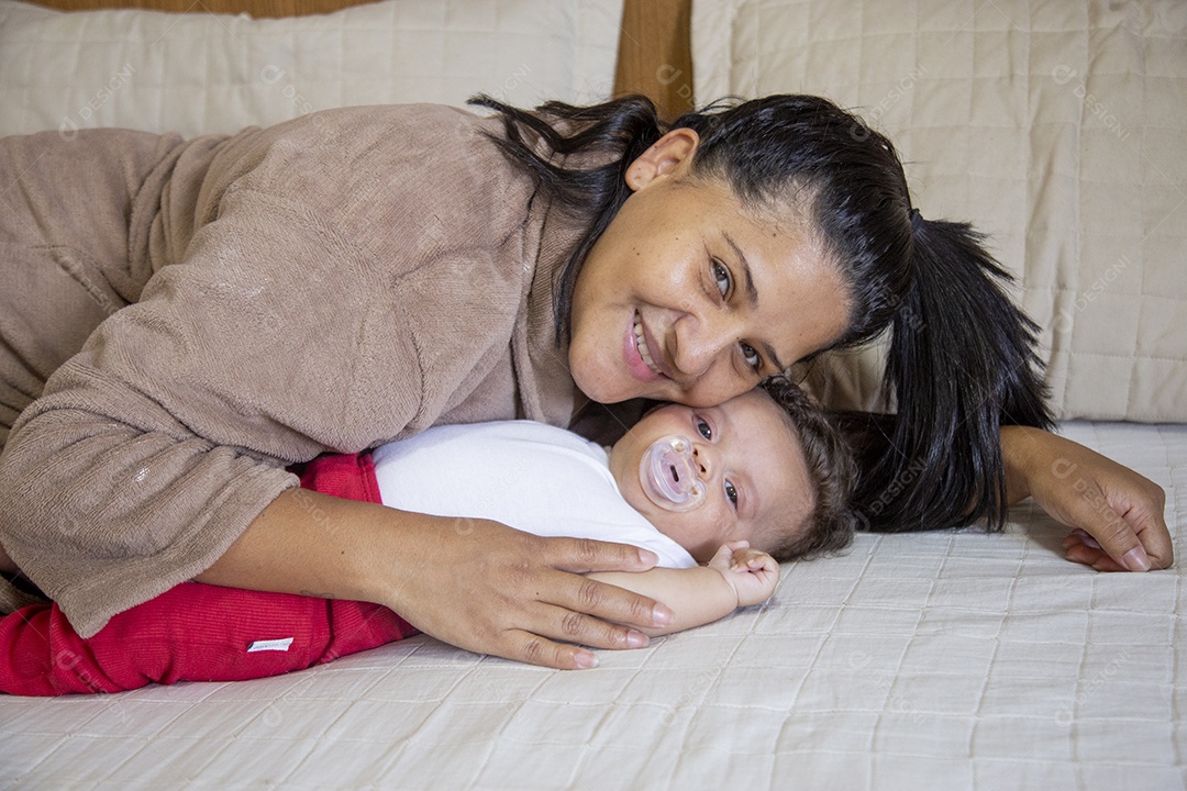 Mãe jovem cuidadando de seu filho sobre quarto