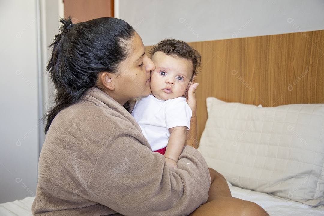 Mãe jovem cuidadando de seu filho sobre quarto