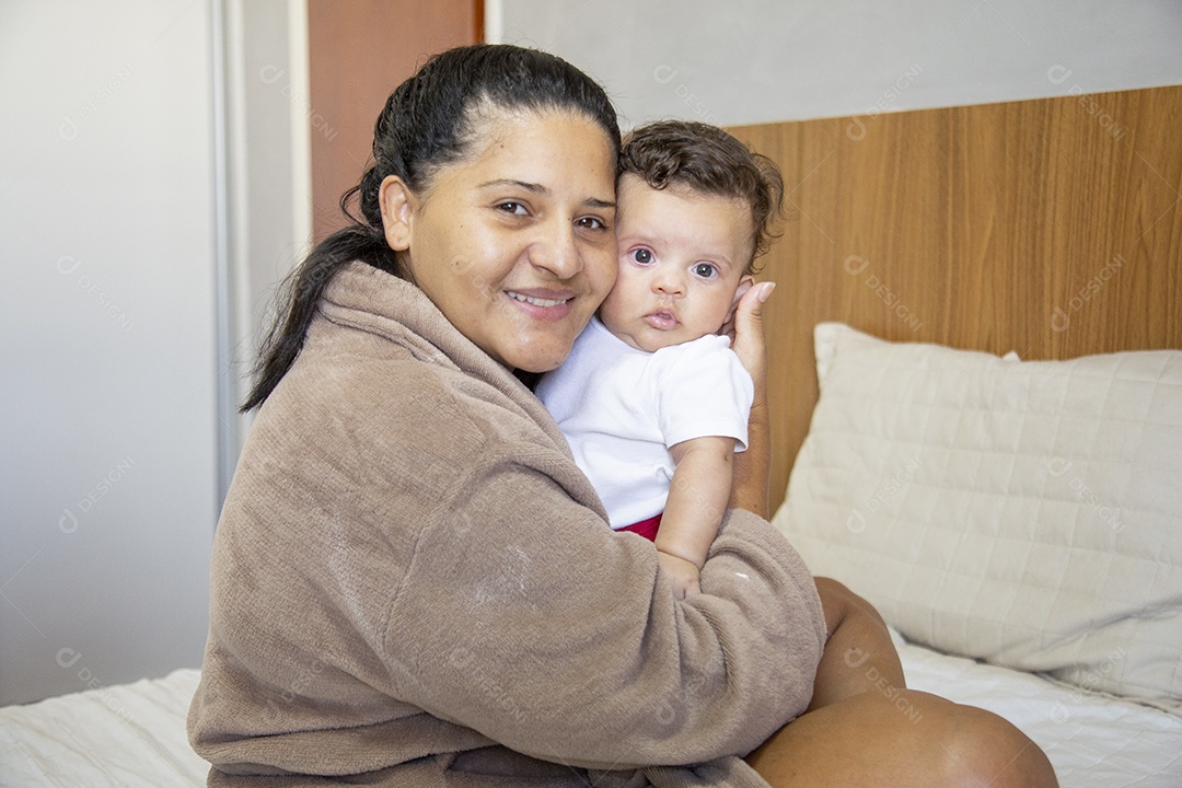 Mãe jovem cuidadando de seu filho sobre quarto